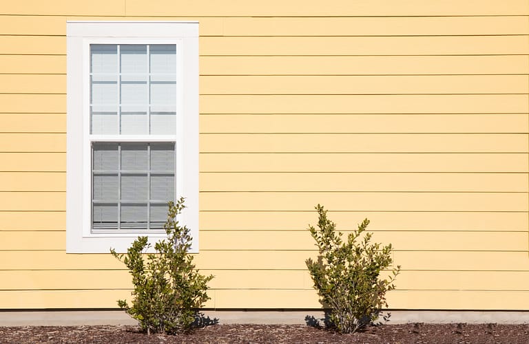 Side view of a house featuring Dutch lap siding, a distinctive style characterized by overlapping horizontal panels with a beveled edge.