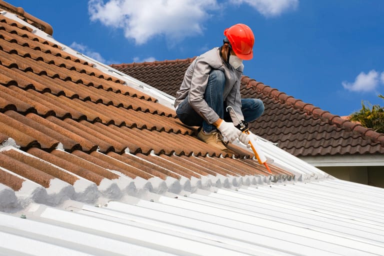 roofer replacing the roof using glue gun on tiles