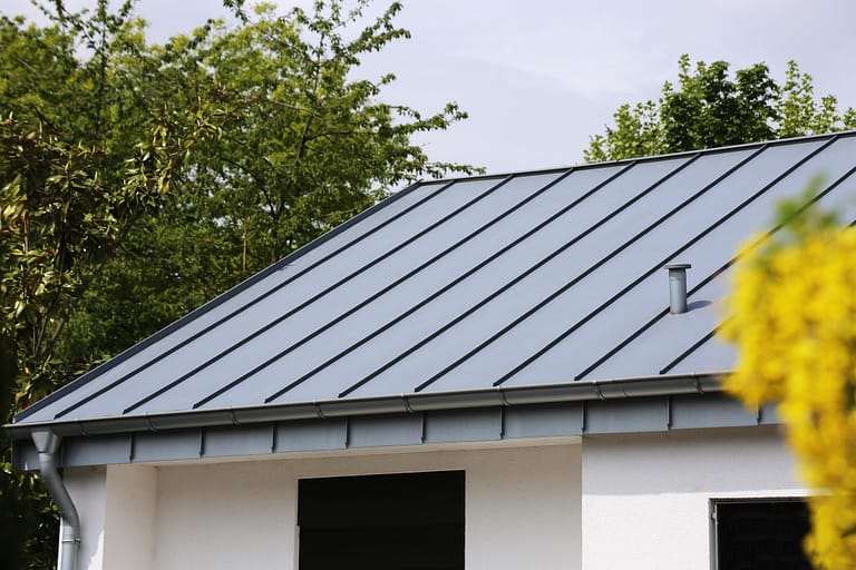 metal roofing panels-dark standing seam metal roofing on a white house