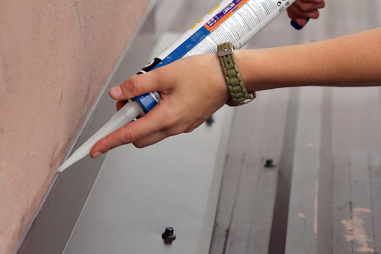 roof sealant-close up view of sealant being applied to jointed areas on a roof