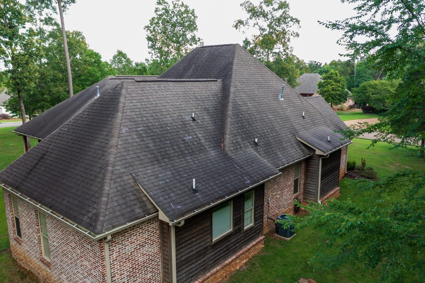 hail damage blisters on asphalt roof shingles and black streaking from storm damage