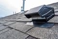 a home with a black roof vent