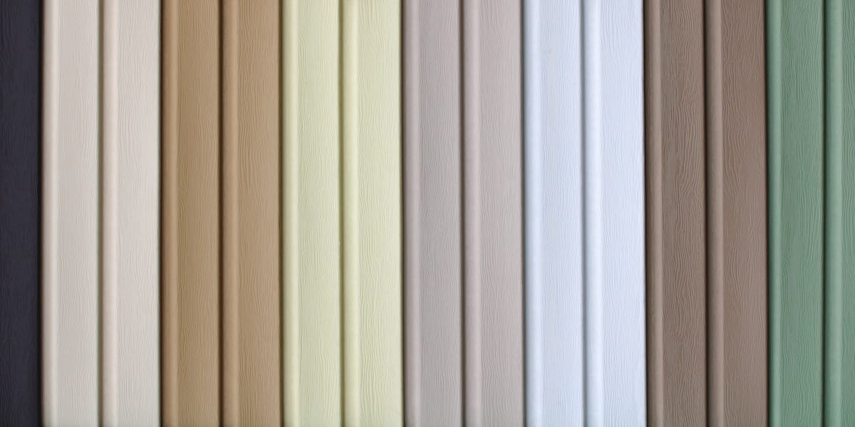 multicolored strips of vinyl siding samples for facing the walls of buildings as a background.