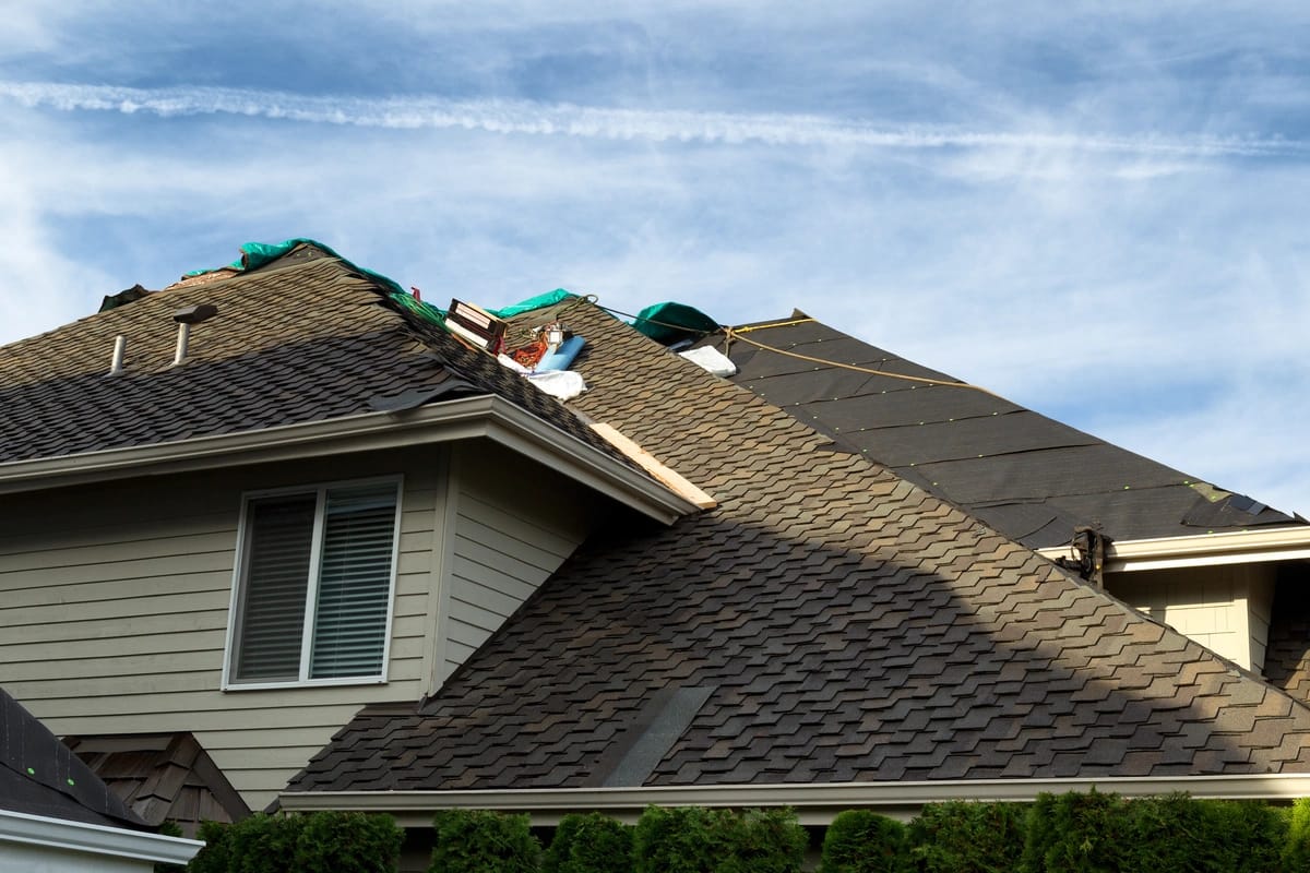 Underlayment being installed on half of a roof