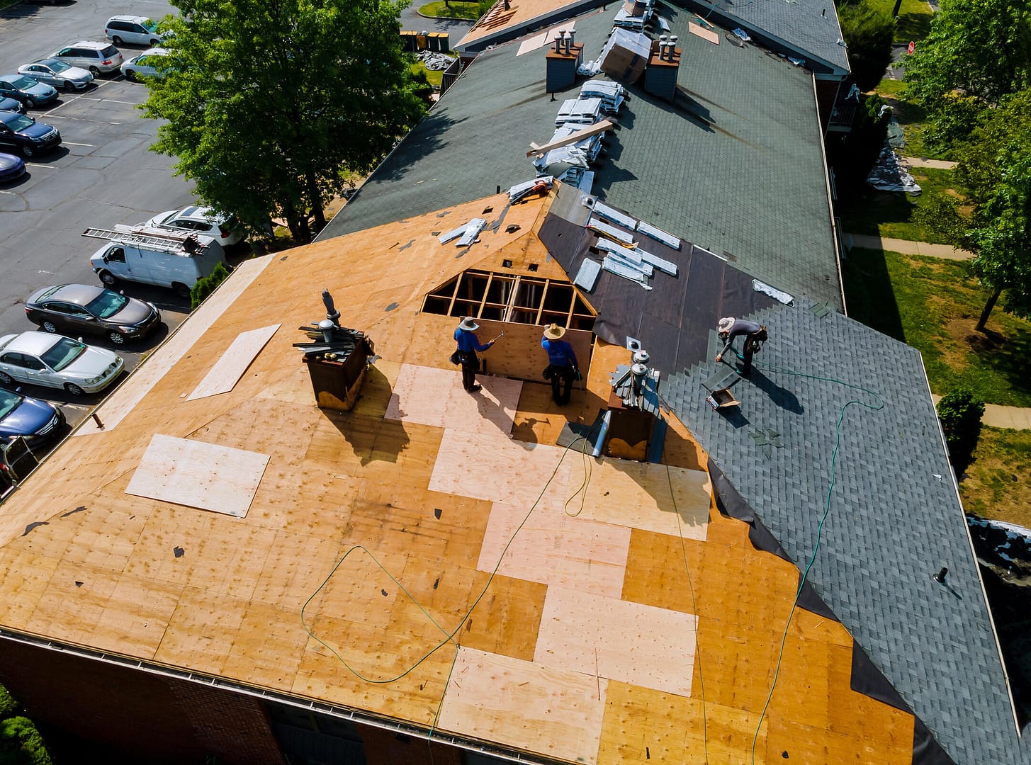 new roof installation-aerial view of a roofing crew installing new shingles on a house roof