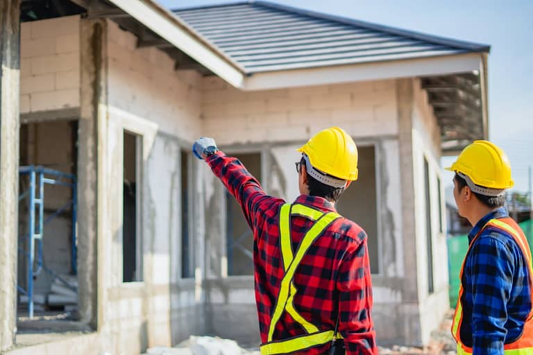 engineers wearing safety helmet and inspecting the house roof