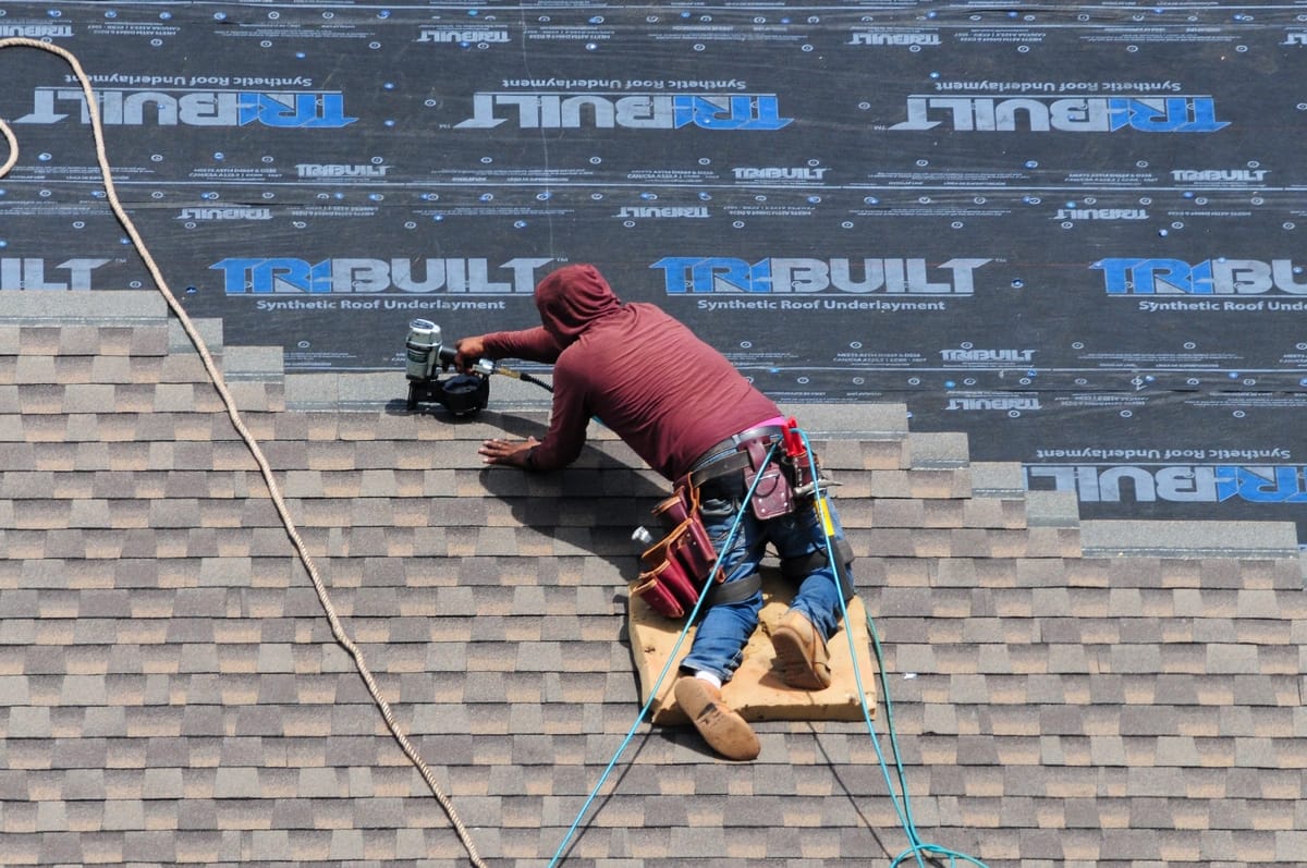 worker installing shingles on Synthetic Roof Underlayment