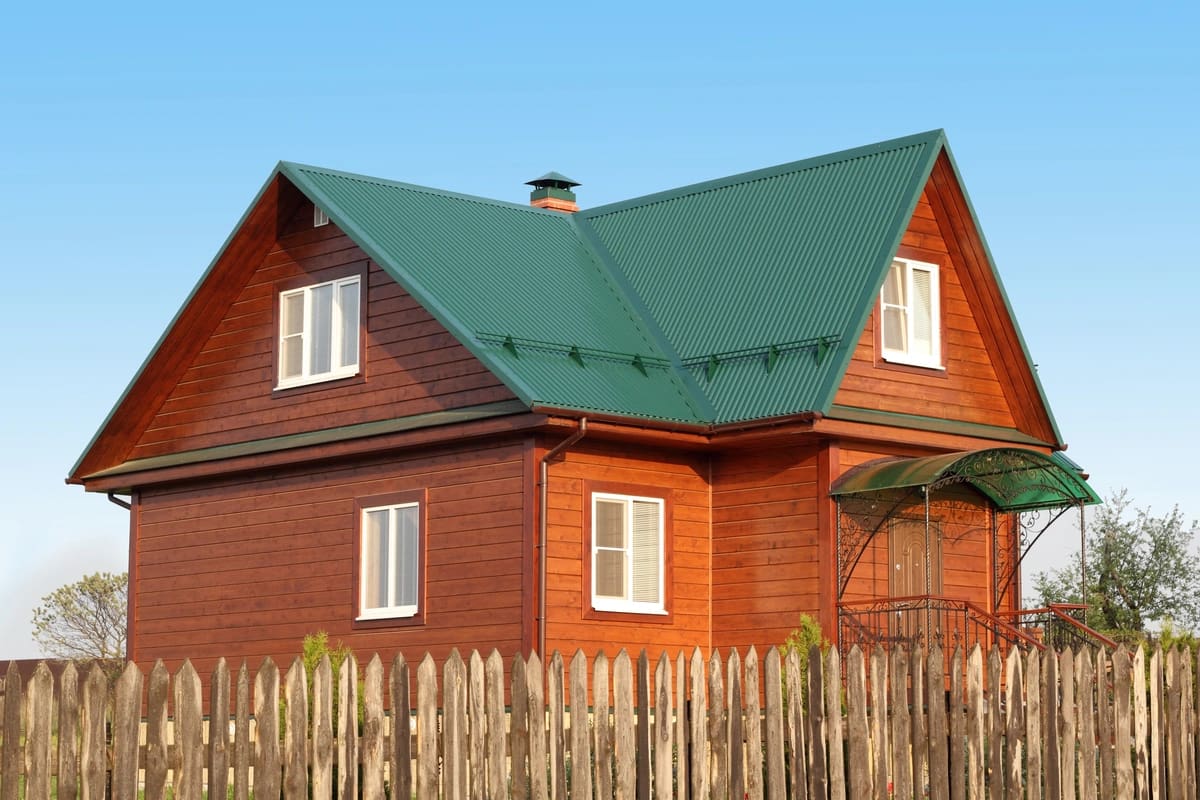 red wooden house with a green metal roof