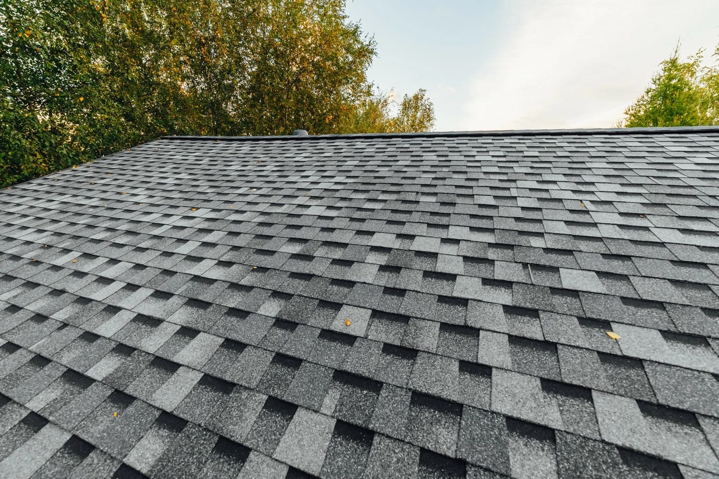close up of new roof section with shingle roof repair after storm damage