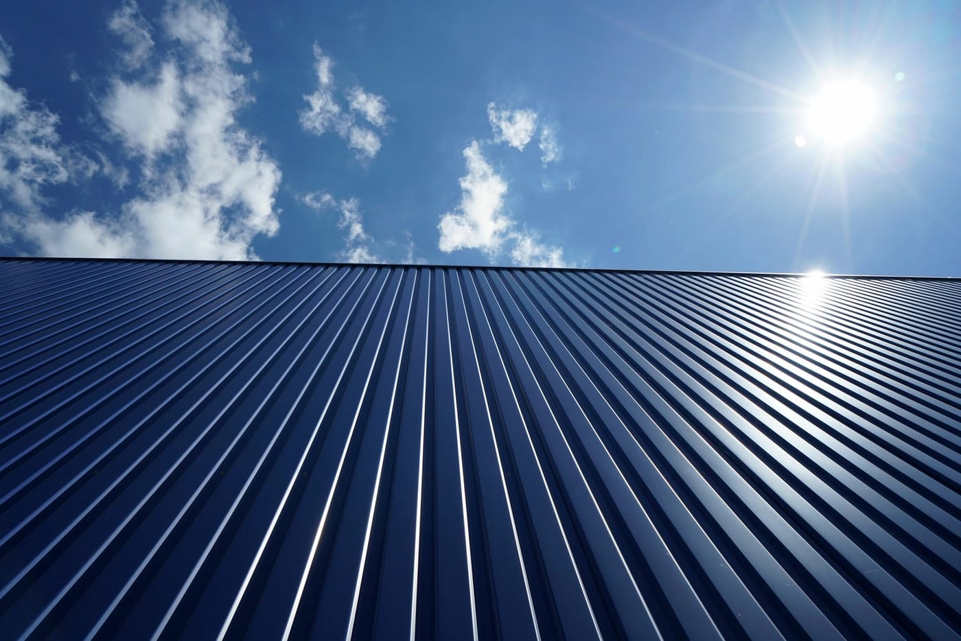 close up of metal commercial roofing system in midlothian va with dark blue corrugated metal roof panels
