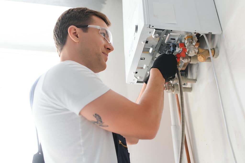 emergency boiler repair Professional boiler service: qualified technician checking a natural gas boiler at home.