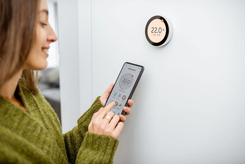 smart thermostat installation woman adjusting temperature inside home using app