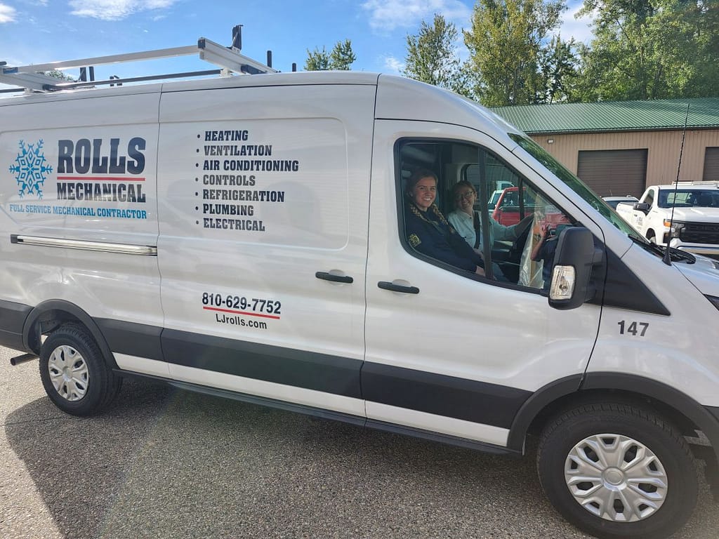 furnace replacement cost Rolls Mechanical white van with two young women driving