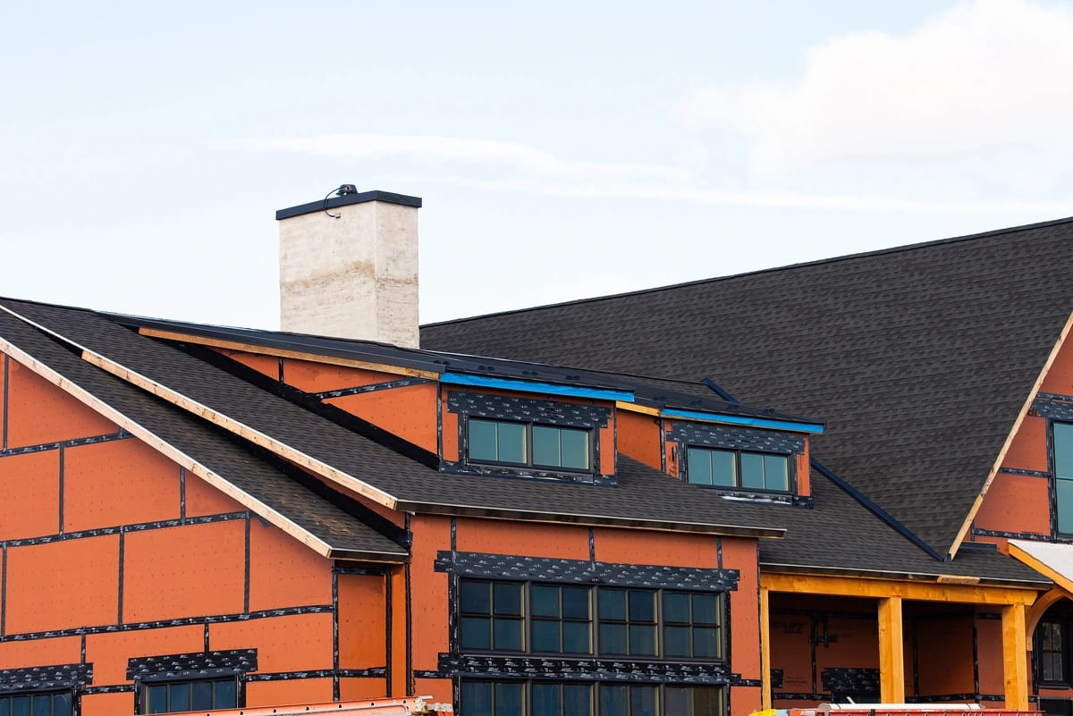 new house construction with a black roof