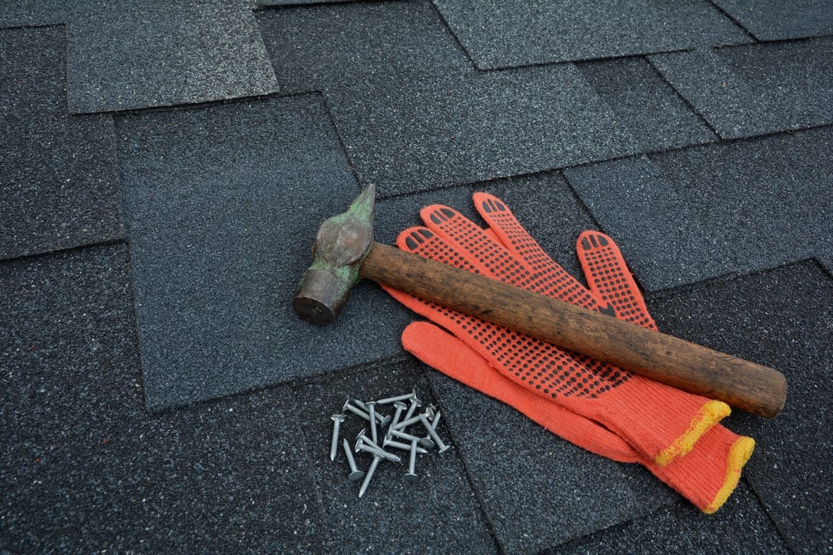hammer and nails on asphalt shingles