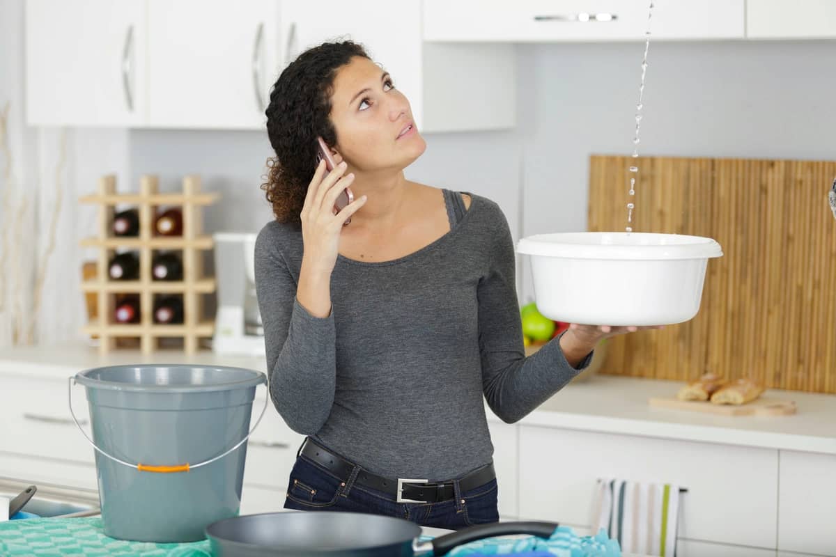 woman catches a leak in a bucket