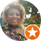 A person smiling outdoors with curly hair, wearing a floral outfit, and a small bird perched on their shoulder. A circular badge with a star symbol is in the lower right corner of the image.