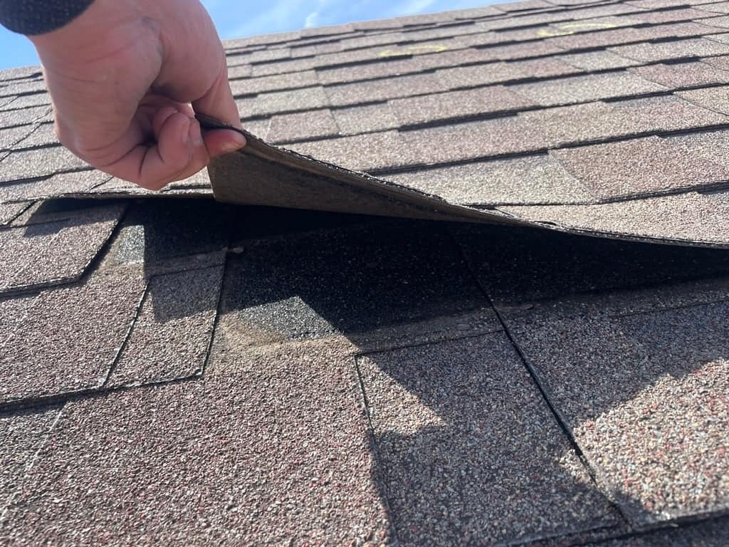 Heartland inspector checking shingles and roof during a roof inspection in Iowa.