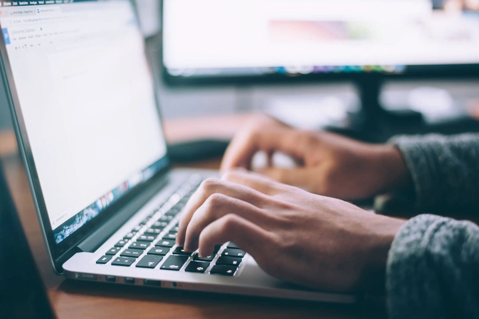 In a vibrant San Francisco office, hands adeptly type on a laptop keyboard, symbolizing the creation of cutting-edge SEO strategies aimed at dominating search results.