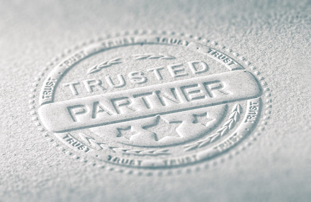 The "Trusted Partner" embossed seal on textured paper, framed by a border of repeated "Trust" and adorned with stars and laurel wreaths, epitomizes the core elements of trust and reliability that are integral to a sophisticated website design.