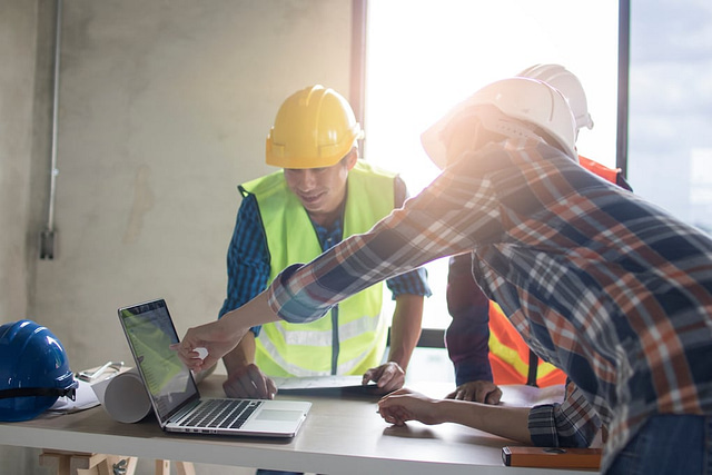 construction team discussing new software construction on table in working site