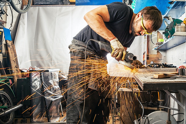man working with a welding machine performing one of the trades in demand