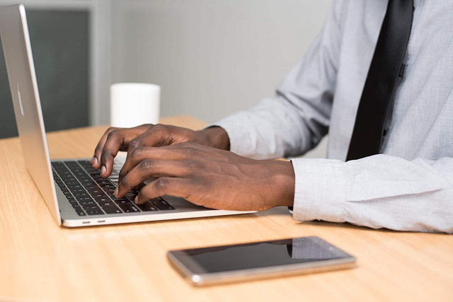 Person sitting at desk and copywriting on a laptop