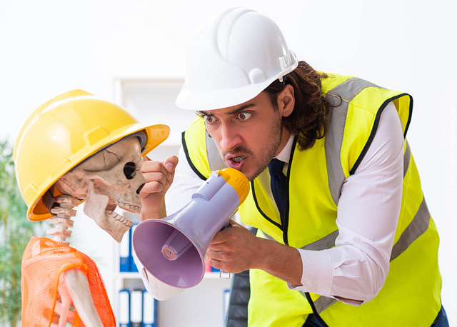 On Hook Agency’s website, a scene depicts a man in a safety vest and hard hat assertively using a megaphone to address a skeleton dressed similarly. This humorous scenario highlights the failures of ineffective marketing strategies and emphasizes the importance of effective solutions.