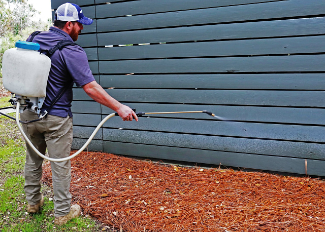 Man spraying house for pests - Pest Control Marketing + Lead Generation