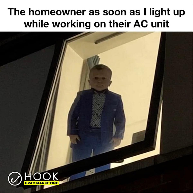 A stern-faced doll, dressed in a blue suit and patterned shirt, stands illuminated against a window at night. The caption above reads, "When the homeowner sees me light up while fixing their AC unit #HVACJokes." The Hook HVAC Marketing logo is displayed in the bottom left corner.