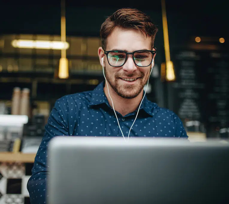 Man wearing headphones and focused on his computer screen, symbolizing the dedication and expertise of an Eau Claire web design agency, creating custom, user-friendly websites to enhance online presence for local businesses.