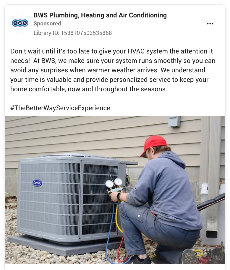 A technician in a red cap and gray shirt efficiently services an outdoor HVAC unit, employing diagnostic tools to guarantee optimal performance. Positioned against a beige building with gravel surroundings, this represents #TheBetterWayServiceExperience—an elite standard recognized and ranked highly by top HVAC companies.