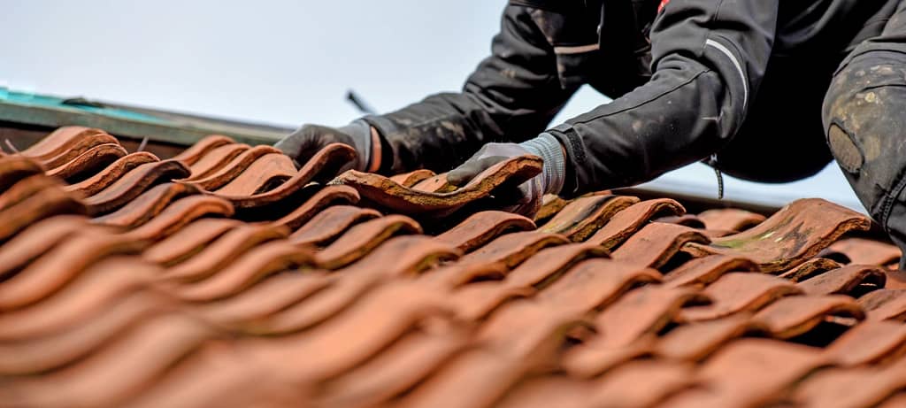 24/7 service roofing crew repairing house roof tiles