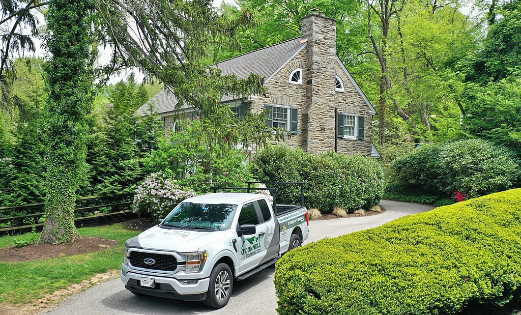 O'Donnell Roofing truck outside a beautiful home ready to perform regular roof maintenance