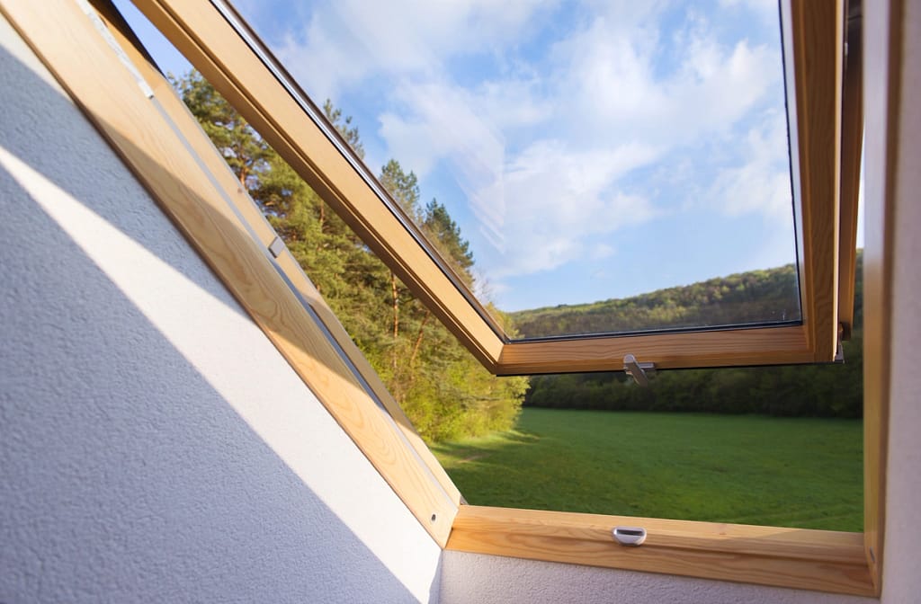 Skylight partially open with a view of a green field