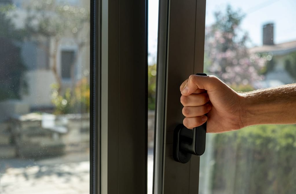 a hand opening a black window