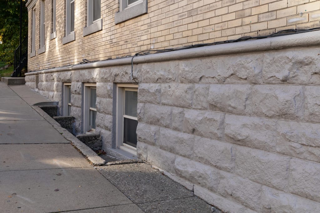 brick home with new egress window installation and small space