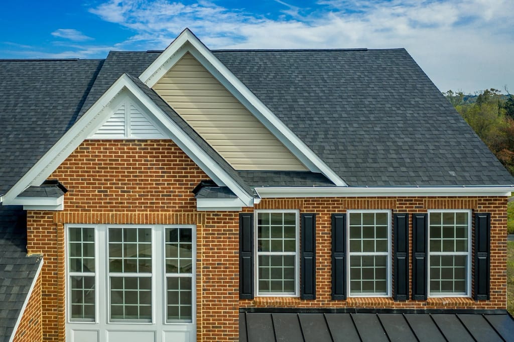 A brick house with black asphalt shingles