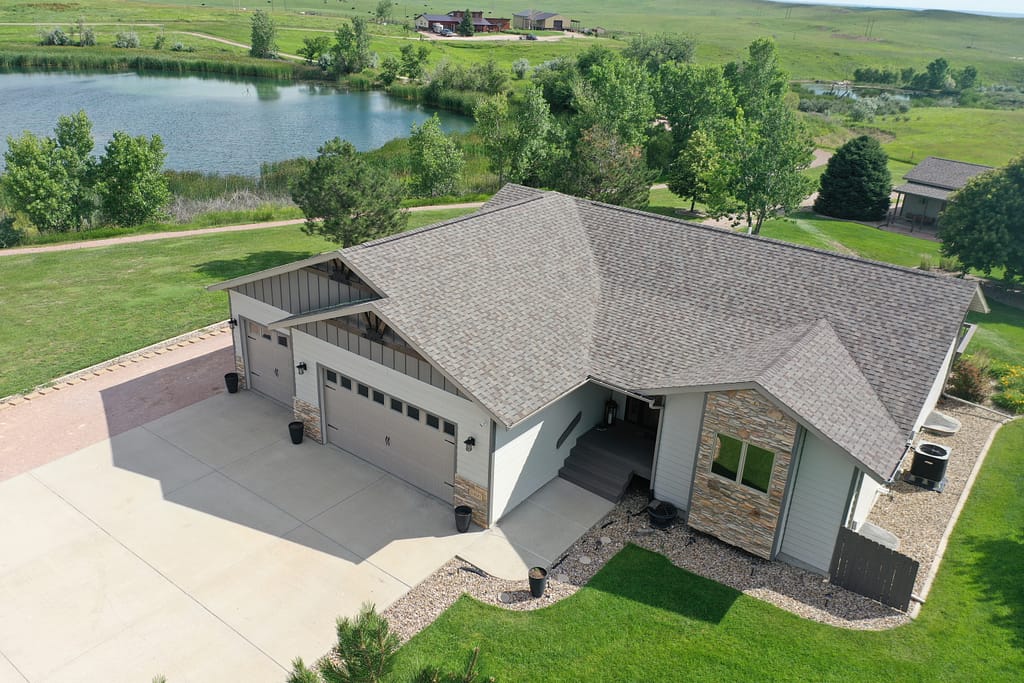 Aerial view of a modern house with light gray siding installation in rapid city sd