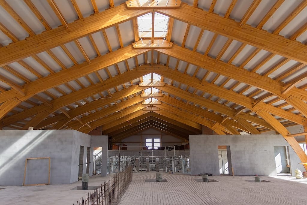 Interior of a large, unfinished building with a high, arched wooden ceiling