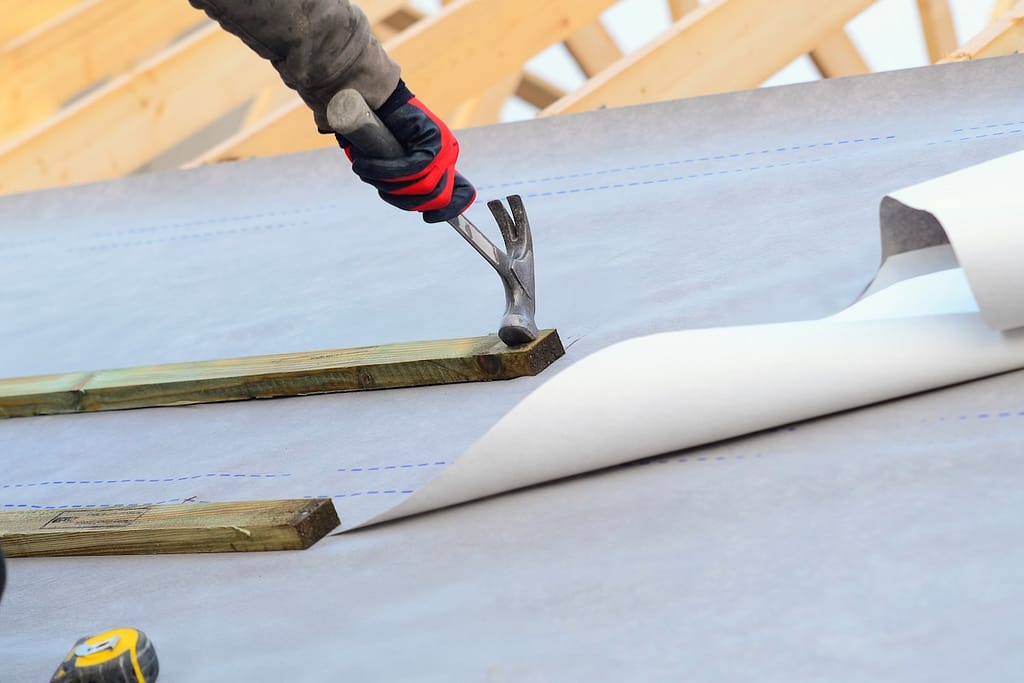 Joiner working on a new house roof making it ready gor roof tiles or slates