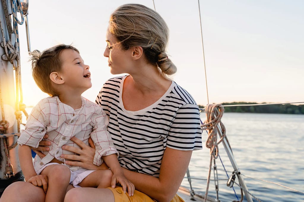 Happy mom and son on sail boat