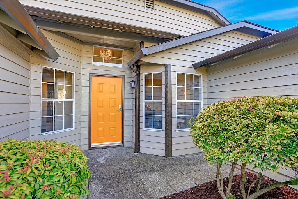 Entrance porch with yellow front door and large windows