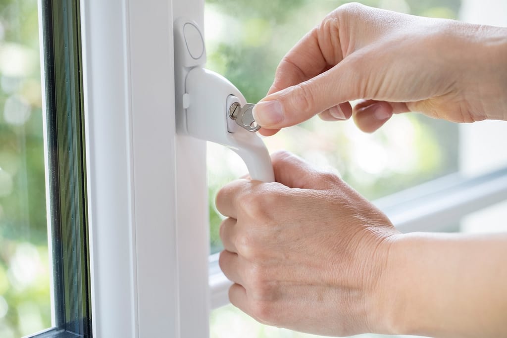 security windows Close Up Of Woman Turning Key In Window Lock