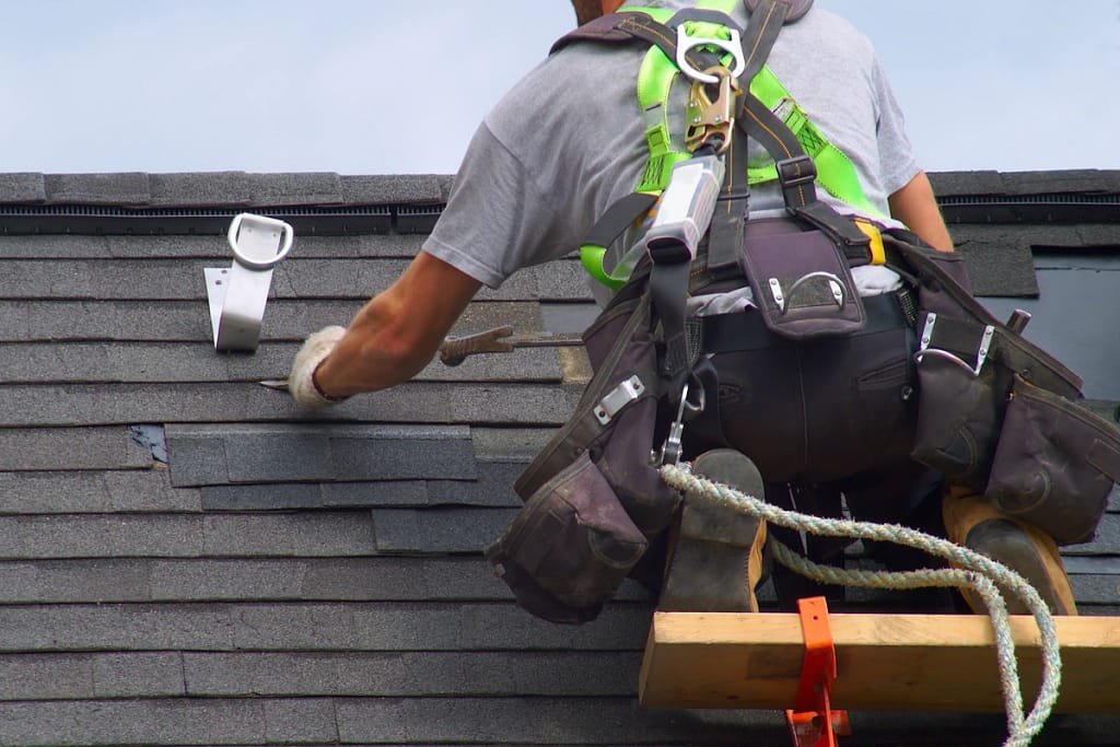 close up of residential roof repair services performed with safety harness