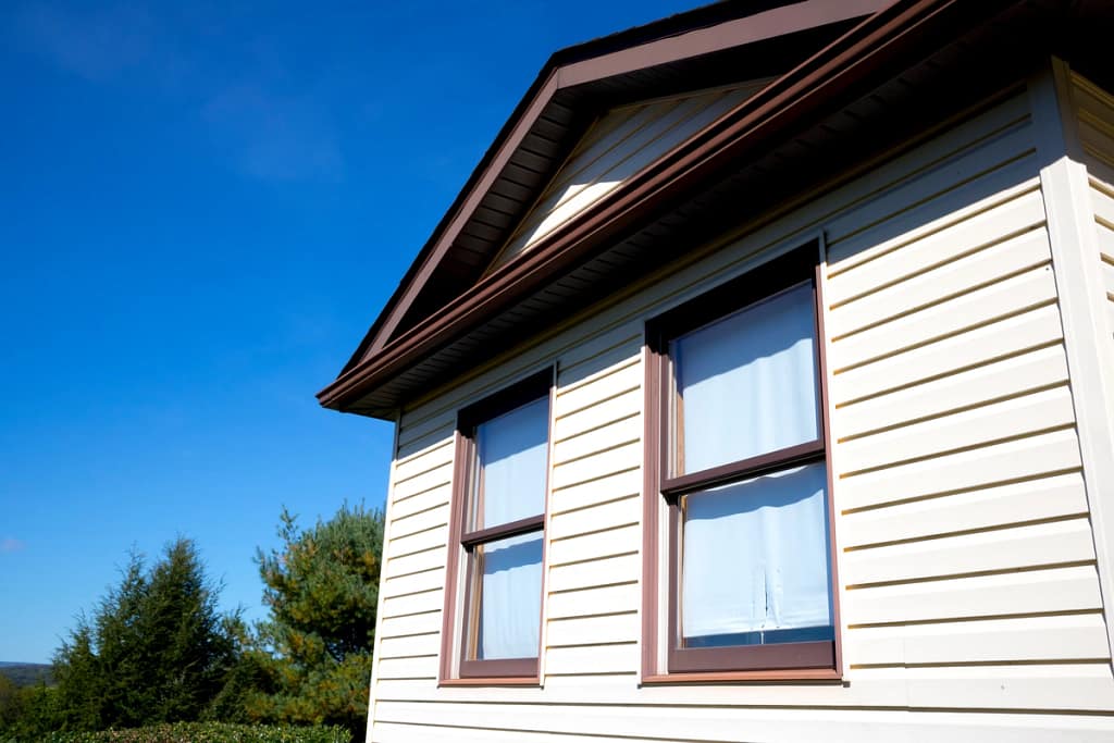close view of beige vinyl siding and with brown accents