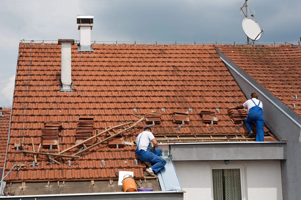 Old house roof is getting replaced by roofing crew