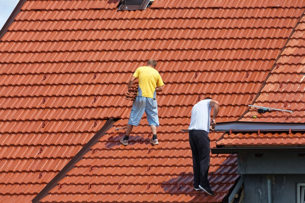 professional roofing team replacing the roof tiles on house