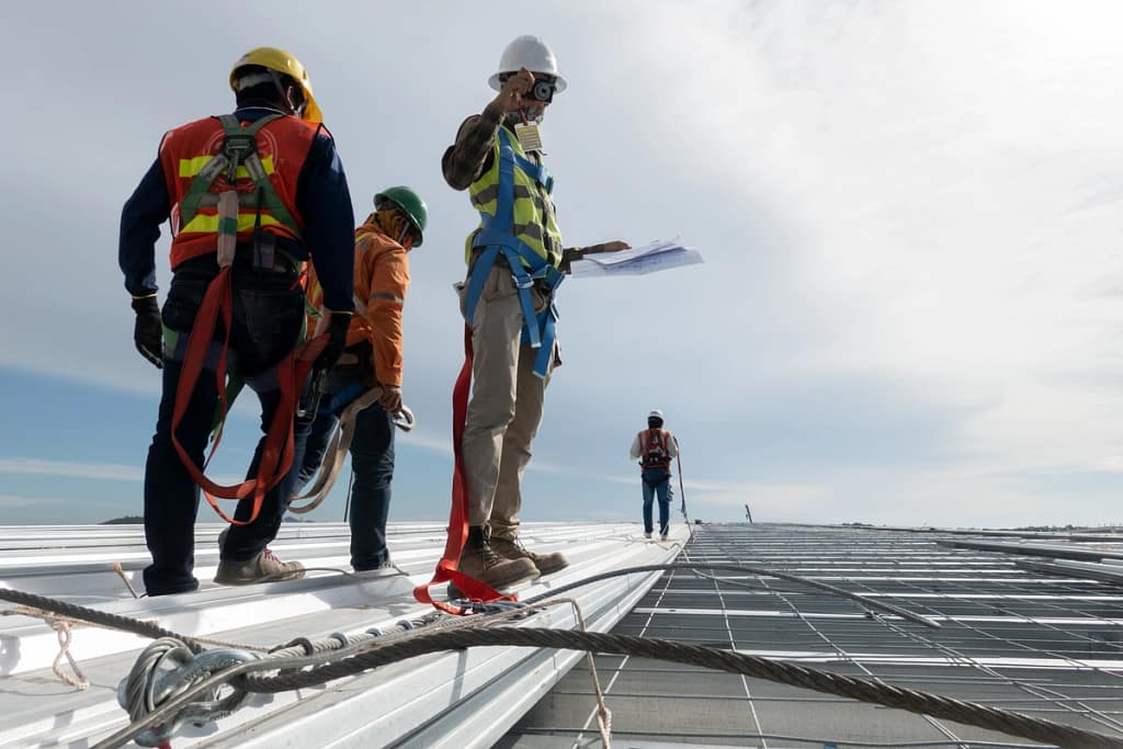 worker inspecting commercial roofing installation