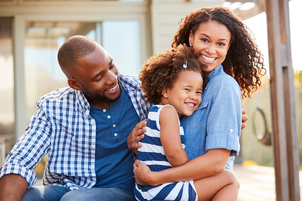 smiling family of three